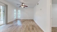 This 500 square foot apartment in Austin, TX offers a thoughtful layout maximizing space efficiency. The open-concept design combines the kitchen and living room, creating a sense of spaciousness. The kitchen features white appliances and two-toned cabinetry, complemented by light wood-look flooring throughout.

The primary bedroom, measuring 110 square feet, includes a ceiling fan and large windows for natural light. Both bedrooms boast ample closet space. The bathroom is well-appointed with a single vanity and a shower/tub combination.

The apartment includes an in-unit laundry area, adding convenience to daily life. Ceiling fans in main living areas help maintain comfort and airflow. The property exterior features white siding and balconies, set amidst landscaped grounds with grassy areas.

Located in a multi-building complex, residents can enjoy community amenities and a suburban feel within the city. The efficient use of space and modern updates make this apartment an attractive option for those seeking a cozy yet functional living environment in Austin.