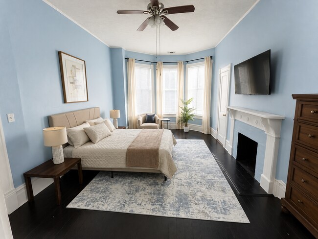 Amplia habitación amueblada con cama de matrimonio y ventanales. - 319 W 33rd St