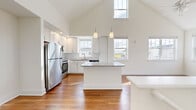 This single-floor, two-bedroom, two-bathroom home in Lebanon, Indiana offers a well-designed layout with notable architectural details throughout. The open-concept living and kitchen area is anchored by dramatically vaulted ceilings that rise to a striking peak, with multiple windows flooding the space with natural light and lending an airy, expansive feel well beyond its physical footprint.

The kitchen is a standout feature, equipped with white shaker-style cabinetry, a granite-topped central island with pendant lighting overhead, stainless steel appliances including a refrigerator, range, microwave, and dishwasher, and a subway tile backsplash. Wood-style flooring flows consistently throughout the entire home, adding warmth and visual continuity.

The primary bedroom benefits from vaulted ceilings and dual windows offering neighborhood views, while the second bedroom is bright and cleanly finished. Both bedrooms include closet storage. The two bathrooms are finished with granite countertops, white cabinetry, and wood-style flooring. The primary bathroom features a sliding glass walk-in shower, while the second bathroom provides a vanity with ample storage. A connecting hallway links the private areas of the home efficiently.