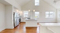 This single-floor, two-bedroom, two-bathroom home in Lebanon, Indiana offers a well-designed layout with notable architectural details throughout. The open-concept living and kitchen area is anchored by dramatically vaulted ceilings that rise to a striking peak, with multiple windows flooding the space with natural light and lending an airy, expansive feel well beyond its physical footprint.

The kitchen is a standout feature, equipped with white shaker-style cabinetry, a granite-topped central island with pendant lighting overhead, stainless steel appliances including a refrigerator, range, microwave, and dishwasher, and a subway tile backsplash. Wood-style flooring flows consistently throughout the entire home, adding warmth and visual continuity.

The primary bedroom benefits from vaulted ceilings and dual windows offering neighborhood views, while the second bedroom is bright and cleanly finished. Both bedrooms include closet storage. The two bathrooms are finished with granite countertops, white cabinetry, and wood-style flooring. The primary bathroom features a sliding glass walk-in shower, while the second bathroom provides a vanity with ample storage. A connecting hallway links the private areas of the home efficiently.