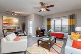 This two-bedroom, two-bathroom unit at Atlantic Vinings in Smyrna, Georgia offers a well-designed, single-floor layout that balances comfort and functionality. A welcoming entry hallway with hardwood-style flooring leads into the heart of the home, where an open-concept living and dining area provides generous space for daily living and entertaining. The living room features a ceiling fan, large windows that invite natural light, and access to a private balcony, creating a bright and airy atmosphere.

The kitchen is open to the living area via a breakfast bar with seating, and is equipped with white cabinetry, granite countertops, a classic subway tile backsplash, and stainless steel appliances, including a built-in microwave and dishwasher. A pantry provides additional storage convenience.

Both bedrooms are carpeted and comfortably sized, each featuring ceiling fans, natural light from large windows, and ample closet space. One bedroom includes a walk-in closet. The neutral color palette throughout creates a calm, cohesive feel.

Each of the two full bathrooms includes a granite-topped vanity, tub-shower combination, and wood-style flooring. The overall design of this unit blends practical finishes with a contemporary aesthetic, making it an inviting residence in the Vinings area of metro Atlanta.