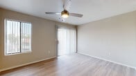 Located at 125 E Guadalupe Rd in Gilbert, AZ, this one-bedroom, one-bathroom unit offers a thoughtfully designed single-floor layout that maximizes comfort and functionality. Light wood-style flooring flows throughout the main living areas, contributing to a bright, cohesive aesthetic.

The open-concept kitchen and living room serve as the heart of the unit. The kitchen is well-appointed with two-tone cabinetry in walnut and light wood finishes, a tile mosaic backsplash, stainless steel appliances including a refrigerator, electric range, and microwave, and a peninsula with a built-in sink — ideal for casual dining or prep work. Track lighting overhead enhances the kitchen's modern appeal.

The living area is airy and naturally lit, featuring vertical blinds over a sliding glass door and an additional side window, along with a ceiling fan for year-round comfort. The bedroom offers plush carpeting, a ceiling fan, and a window with vertical blinds, creating a calm and restful retreat. A dedicated closet provides practical storage.

The bathroom is clean and functional, featuring a dark wood vanity with a white countertop and undermount sink, a large mirror, and a full tub-shower combo. A hallway with a distinctive arched doorway connects the rooms, adding a subtle architectural detail to the overall design.