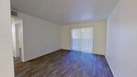 This efficient single-floor, one-bedroom, one-bathroom unit is thoughtfully laid out to make the most of its compact footprint. The living room serves as the heart of the space, featuring durable wood-style plank flooring, neutral cream-toned walls, and a large sliding glass door dressed with vertical blinds that allows natural light to fill the room and provides an outdoor connection.

The galley-style kitchen is neatly arranged with white cabinetry, speckled stone countertops, a stainless steel sink, and black appliances including a gas range and full-size refrigerator. A door at the end of the kitchen leads to additional access within the unit.

The bedroom is a comfortable, well-proportioned room finished with plush carpet, a ceiling fan, a window with horizontal blinds for natural light and privacy, and a closet with a paneled door for ample storage.

The bathroom is clean and functional, featuring a full-size soaking tub and shower combination with white subway tile surround, brushed nickel fixtures, and a toilet. The space is completed by a hallway and entrance area that connect the rooms efficiently. Throughout the unit, the light color palette and consistent finishes create a cohesive, move-in-ready atmosphere.