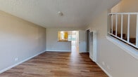 Located at 518 Carobe Ct in Union City, California, this two-story home offers a practical and well-organized layout across both levels. The main floor welcomes visitors through a paneled front door into a bright entry area featuring wood-style flooring that extends throughout the lower level. A large vertical-blind window fills the entry with natural light, while a staircase leads to the upper floor.

The living and dining areas flow openly, connected to the kitchen via a pass-through counter with granite-style surfaces. The kitchen is equipped with warm honey-toned oak cabinetry, a white electric range with overhead ventilation, a refrigerator, dishwasher, and a sliding glass door that opens to the exterior, allowing abundant natural light. A full bathroom on the main level provides added convenience.

Upstairs, the bedrooms feature plush carpeting and textured ceilings. One bedroom includes a ceiling fan with light fixture and a window with outdoor views of surrounding greenery. Another bedroom is fitted with mirrored sliding closet doors offering built-in shelving. Neutral wall tones are consistent throughout, creating a cohesive and calm ambiance across both floors.