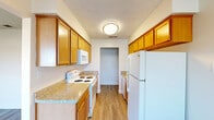 Located at 4918 N 9th St in Fresno, CA, this single-floor, 2-bedroom, 2-bathroom unit offers a well-organized and functional layout. The galley-style kitchen is efficiently designed with warm honey-toned wood cabinetry, granite-look countertops, white appliances including a refrigerator, electric range, and microwave, all set atop durable wood-look flooring. The kitchen flows seamlessly into a combined dining area, which is brightened by a window and ceiling fan, and connects to the living room via an open sightline. The living room features hardwood-style flooring and a sliding glass door that opens to a private balcony, bringing in natural light and outdoor views. Both bedrooms are carpeted and feature windows with views of surrounding greenery, offering a calm and comfortable atmosphere. Four closets distributed throughout the unit provide generous storage. The two bathrooms are appointed with wood-toned vanities, granite-look countertops, and large mirrors. A connecting hallway ties the layout together efficiently. Textured ceilings are found throughout, adding a consistent design element across all rooms. The overall ambiance is clean, practical, and move-in ready.