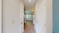 Located at 3050 Old River Road in Jacksonville, FL, this two-story home offers a thoughtfully designed layout spread across two floors. The main level features an open-concept living, dining, and kitchen area bathed in natural light from multiple windows with views of lush greenery. The kitchen is outfitted with crisp white shaker cabinets, quartz countertops, stainless steel appliances including a range, microwave, and dishwasher, and light wood-look flooring that flows seamlessly throughout the main living areas. A ceiling fan anchors the bright living room, which connects to a welcoming entrance hall lined with panel doors and ample closet storage. The upper floor houses both bedrooms, each featuring plush carpet, ceiling fans, and windows that invite natural light. The spacious primary bedroom is complemented by a well-appointed bathroom showcasing white shaker vanity cabinetry, quartz countertops, and gold-accented fixtures beneath stylish modern lighting. Four closets throughout the home provide generous storage. A dedicated laundry room with full-size washer and dryer and additional cabinetry adds everyday convenience. The attached garage and two staircases complete this functional and modern Jacksonville home.