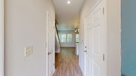 Located at 3050 Old River Road in Jacksonville, FL, this two-story home offers a thoughtfully designed layout spread across two floors. The main level features an open-concept living, dining, and kitchen area bathed in natural light from multiple windows with views of lush greenery. The kitchen is outfitted with crisp white shaker cabinets, quartz countertops, stainless steel appliances including a range, microwave, and dishwasher, and light wood-look flooring that flows seamlessly throughout the main living areas. A ceiling fan anchors the bright living room, which connects to a welcoming entrance hall lined with panel doors and ample closet storage. The upper floor houses both bedrooms, each featuring plush carpet, ceiling fans, and windows that invite natural light. The spacious primary bedroom is complemented by a well-appointed bathroom showcasing white shaker vanity cabinetry, quartz countertops, and gold-accented fixtures beneath stylish modern lighting. Four closets throughout the home provide generous storage. A dedicated laundry room with full-size washer and dryer and additional cabinetry adds everyday convenience. The attached garage and two staircases complete this functional and modern Jacksonville home.