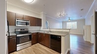 Located at 6715 E Union Ave in Denver, CO, this well-appointed two-bedroom, three-bathroom residence offers a thoughtfully designed single-floor layout. The open-concept kitchen features rich dark wood cabinetry, granite countertops, a hexagonal tile backsplash, and stainless steel appliances including a range, microwave, and dishwasher. A peninsula counter connects the kitchen seamlessly to the living area, which is highlighted by crown molding, wood-style plank flooring, a ceiling fan, and a striking fireplace with a classic white surround — an inviting focal point in the room. Natural light flows in through multiple windows, and a private exterior door provides direct outdoor access from the living space. Both bedrooms are carpeted and equipped with ceiling fans and windows with outdoor views. The generously sized primary bedroom includes a walk-in closet outfitted with wire shelving on multiple walls for ample storage. The bathrooms are consistently finished with granite-topped dark wood vanities, large mirrors with modern lighting, and hardwood-style flooring. One full bathroom features a tub-shower combination. Crown molding and cohesive finishes throughout give this residence a clean, polished aesthetic.