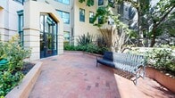 Located at 639 Geary Street in San Francisco's vibrant Tenderloin/Lower Nob Hill neighborhood, this ground floor common area offers a thoughtfully designed outdoor courtyard that provides a welcome retreat from the urban surroundings. The space features a classic herringbone-patterned brick walkway that winds through generously landscaped raised planting beds, filled with a rich variety of shrubs, ornamental grasses, flowering trees, and drought-tolerant plants that add color and texture throughout the seasons. Mature trees provide natural shade and a sense of established greenery, while the warm tones of the brick hardscape complement the building's architecture. Seating is well distributed throughout the courtyard, including metal benches along the perimeter and a table-and-chair set ideal for outdoor dining or casual gathering. The space is open to the sky, allowing abundant natural light to fill the area, and offers views of the surrounding San Francisco cityscape, including neighboring mid-rise and high-rise buildings. Framed by the multi-story residential building on one side, the courtyard benefits from a sheltered, semi-private atmosphere while remaining accessible as a shared common amenity. This outdoor common area is a notable feature of the property, offering residents a functional and pleasant green space in a dense urban setting.
