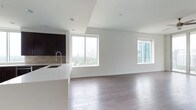 This single-floor space showcases a thoughtfully designed open-concept layout that seamlessly integrates the kitchen and living areas into one cohesive environment. Rich, dark hardwood flooring extends throughout, adding warmth and contrast against the crisp white walls and ceilings. Recessed lighting is installed overhead, providing even, unobtrusive illumination across the space.

The kitchen is outfitted with dark espresso cabinetry, a neutral tile backsplash, and a clean white countertop that extends into a peninsula with an integrated sink — offering both functional workspace and a subtle visual boundary between the kitchen and living area. The modern faucet adds a refined finishing touch.

Large sliding windows dominate the exterior walls, flooding the interior with natural light and framing impressive views of a city skyline and surrounding greenery. The living area benefits from this abundant natural light, creating an airy, open ambiance. A second window on the adjacent wall further enhances ventilation and views of neighboring modern architecture. The overall aesthetic is clean, minimalist, and well-suited to contemporary urban living.