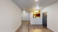 Located in Vancouver, WA, this 2-bedroom, 1-bathroom unit offers a well-designed single-level layout that maximizes functionality throughout. The open-concept living and dining area is finished with warm wood-look luxury vinyl plank flooring, neutral-toned walls, and recessed lighting, creating a bright and welcoming atmosphere. A sliding glass door provides access to an outdoor area and allows natural light to fill the space.

The kitchen is a standout feature, showcasing rich walnut-toned cabinetry, stainless steel appliances including a refrigerator, range, microwave, and dishwasher, along with light countertops and a peninsula that opens toward the dining and living areas. A dedicated laundry room adds everyday convenience.

Both bedrooms are carpeted and bathed in natural light through large windows with blinds that frame views of the surrounding neighborhood. The spacious primary bedroom offers a generous footprint, while the second bedroom is equally bright and comfortable. Three closets throughout the unit provide ample storage.

The bathroom features a clean, modern design with a wood-toned vanity, white countertop, large mirror, and a full tub-shower combination. The cohesive design language throughout the unit — combining warm wood tones, neutral walls, and contemporary fixtures — creates a comfortable and polished living environment.