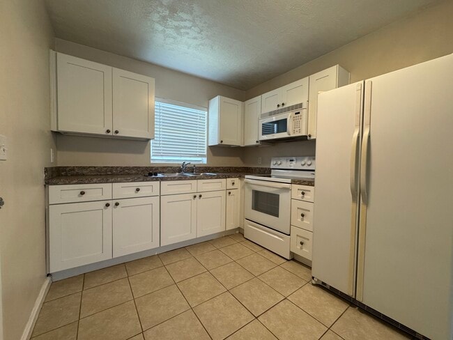 Kitchen with double sink, oven/stove, microwave, fridge - 405 Upper 8th Avenue South