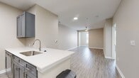 This contemporary 700 square foot apartment in Towson, MD offers a thoughtfully designed living space. The open floor plan creates a seamless flow between the living areas, maximizing the use of space. The kitchen boasts sleek gray cabinetry, stainless steel appliances, and a convenient breakfast bar, perfect for casual dining or entertaining.

The bedroom, measuring 150 square feet, features large windows that flood the space with natural light. The bathroom is equipped with a modern vanity, ample storage, and a spacious walk-in shower. A generously sized closet provides excellent storage solutions.

Throughout the apartment, wood-look flooring adds warmth and elegance, while neutral-toned walls create a blank canvas for personal decor. The living room area is spacious and versatile, ideal for relaxation or hosting guests. High ceilings and recessed lighting contribute to the airy, open feel of the space.

Energy-efficient features include modern light fixtures and a programmable thermostat. The apartment's layout and finishes reflect a commitment to both style and functionality, making it an attractive option for those seeking a contemporary living space in Towson.