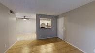 This single-floor unit offers a clean, functional layout designed for comfortable everyday living. The open living and dining area is finished with warm, large-format tile flooring and features a ceiling fan overhead. A textured ceiling runs throughout the space, adding a classic residential touch. A distinctive accent wall with a pass-through window connects the living area to the kitchen, creating an open and communicative flow between the two spaces.

The kitchen is well-equipped and practical, featuring white cabinetry with ample storage, gray laminate countertops, a subway tile backsplash, and stainless steel appliances including a range, refrigerator, and dishwasher. Recessed lighting illuminates the kitchen, and a utility door at the rear provides additional access.

The bedroom is a calm, neutral-toned room with natural light streaming in through a window fitted with blinds, continuing the light tile flooring found throughout. A sliding-door closet offers generous storage space with a full-width hanging rod.

The living room also features a sliding glass door covered by vertical blinds, allowing for natural light control and potential outdoor access. Overall, the space presents a cohesive, neutral palette of grays and warm whites, creating a bright and move-in-ready environment.