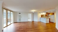 This thoughtfully designed single-floor residence offers three bedrooms and two bathrooms within a comfortable and practical layout. The open-concept living and dining area is anchored by rich hardwood flooring that flows throughout the main living spaces, creating a warm and cohesive feel. Large windows frame urban city views, allowing natural light to fill the room.

The kitchen is well-equipped with warm wood cabinetry, recessed lighting, white appliances including a range and refrigerator, and generous counter space. A peninsula with a breakfast bar counter connects the kitchen to the living area, making it ideal for casual dining and entertaining.

The primary bathroom features a granite-topped vanity with warm wood cabinetry and a mirrored medicine cabinet, while the second bathroom includes a tiled tub-shower combination with decorative tile accents and a granite vanity.

The bedrooms are carpeted for comfort and each benefits from large windows with city views. The primary bedroom offers dual closets with built-in shelving and hanging rods, providing ample storage. The additional bedrooms are equally bright and well-proportioned. Crown molding and clean white walls throughout the living areas contribute to a polished, move-in-ready ambiance.