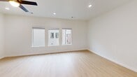 Located at 1982 S Razorback Rd in Fayetteville, AR, this contemporary three-bedroom, three-bathroom home is thoughtfully designed across three floors. Light hardwood flooring flows throughout, complementing a clean, neutral palette of crisp white walls and modern black hardware accents.

The main living level features an open-concept kitchen and living room. The kitchen is equipped with stainless steel appliances, light wood cabinetry, white countertops, and direct access to an outdoor balcony. The living area is anchored by a sleek built-in fireplace with a minimalist wood mantle and ceiling fan overhead.

The upper floor hosts the bedrooms, including a generously sized primary suite with vaulted ceilings, a walk-in closet, and an en-suite bathroom featuring a glass-enclosed walk-in shower with marble-style tile and matte black fixtures. Additional bedrooms are bright and well-proportioned, each with ceiling fans and easy access to well-appointed bathrooms with warm wood vanities and white countertops.

A dedicated laundry room with a full-size washer and dryer adds convenience, while the ground-floor garage provides secure parking and storage. The home's modern design, quality finishes, and efficient layout make it a well-appointed residence in the heart of Fayetteville.