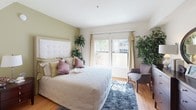 Located in the heart of downtown Los Angeles, this well-appointed single-floor residence at 725 S Bixel St offers a thoughtfully designed layout with a refined, contemporary aesthetic throughout. The living room serves as the centerpiece of the home, featuring warm hardwood flooring, crown molding, and a gallery wall of framed artwork. Large sliding glass doors flood the space with natural light and open directly onto a private balcony, providing outdoor views of the surrounding cityscape — perfect for relaxing or entertaining. The kitchen is a galley-style space with light maple cabinetry, dark granite countertops, a bold patterned accent wall, and full black appliance suite, combining function with character. The dining area is highlighted by track lighting overhead, a glass-top table, and a large floor mirror that enhances the sense of space. The bedroom is a serene retreat with an accent wall in muted sage green, a tufted upholstered headboard, sliding glass doors to an additional outdoor space, and ample natural light. A built-in stacked washer and dryer unit is conveniently located just off the bedroom. The bathroom features light maple cabinetry, a wide vanity with a well-lit mirror, and a combined tub and shower enclosure. Built-in storage cabinetry adds practical elegance to the hallway areas.