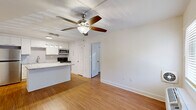 Located at 401 W Park Ave in Tallahassee, FL, this thoughtfully designed one-bedroom, one-bathroom residence offers a smart and functional layout across a single floor. Warm hardwood-style flooring flows seamlessly throughout the entire space, creating a cohesive and inviting atmosphere.

The open-concept living, dining, and kitchen area serves as the heart of the home. The kitchen is a standout feature, equipped with stainless steel appliances including a refrigerator, range, and microwave, complemented by crisp white shaker cabinetry, granite countertops, and a central island with additional seating and prep space. A ceiling fan with integrated lighting overhead adds comfort to the living area.

The bedroom is a well-proportioned retreat featuring a ceiling fan, a window that brings in natural light, and a dedicated closet with bi-fold doors. Conveniently adjacent to the bedroom is an in-unit washer, accessible through the hallway.

The bathroom is finished with a marble-style tiled tub and shower surround, granite countertops, and hardwood-style flooring, lending a clean, polished aesthetic. A pantry provides additional storage, rounding out the practical amenities of this well-appointed residence.