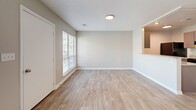 This 540 square foot, single-story apartment in Fayetteville, NC, offers a thoughtfully designed living space. The open-concept layout combines the kitchen and living room, maximizing the available area. The kitchen boasts modern amenities, including granite countertops, stainless steel appliances, and ample cabinet space. Light-colored wood-look flooring throughout the main living areas creates a bright, cohesive appearance.

The spacious bedroom, measuring 150 square feet, features plush carpeting and a ceiling fan for comfort. Large windows in both the bedroom and living room allow natural light to flood the space, while horizontal blinds offer privacy when needed. The bathroom is equipped with a full-size bathtub and shower combination, complete with safety grab bars.

Storage solutions are integrated throughout, with closet space in the bedroom and additional storage options. The neutral color palette of whites and light grays provides a clean, contemporary aesthetic that allows for personalization. Recessed lighting and modern fixtures contribute to the overall updated feel of the apartment. Despite its compact size, this one-bedroom home efficiently utilizes every square foot to create a comfortable and functional living environment.