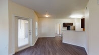 Located at 2650 S Forum Dr in Grand Prairie, Texas, this single-story residence offers a well-organized, functional layout designed for comfortable everyday living. The open-concept living area is a standout feature, showcasing rich dark hardwood-style flooring, vaulted ceilings with a ceiling fan, and a glass-paneled door that allows natural light to fill the space. The living area flows seamlessly into the kitchen, which is equipped with dark espresso cabinetry, light-toned countertops, and a full suite of stainless steel appliances including a refrigerator, gas range, microwave, and dishwasher. A breakfast bar creates a natural transition between the kitchen and living space. The bedroom features plush carpeting and is paired with a spacious walk-in closet outfitted with wire shelving for organized storage. The bathroom offers a full tub and shower combo, dark vanity cabinetry, a wall mirror, and hardwood-style flooring. A dedicated utility closet houses the water heater and provides washer/dryer hookup connections. Neutral wall tones throughout lend a clean, move-in-ready aesthetic, while the overall layout maximizes the sense of space across every room.