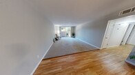 This single-floor residence offers a clean, neutral aesthetic throughout, with a thoughtful layout that balances open common areas with private sleeping quarters. The living room is generously proportioned, featuring a combination of hardwood flooring at the entry that transitions to plush carpeting across the main seating area. A large sliding glass door fills the space with natural light and provides direct access to a private outdoor patio, where views of surrounding greenery contribute to a calm, natural ambiance. A ceiling fan overhead adds functional comfort to the room.

The galley-style kitchen is efficiently designed with light maple cabinetry, granite-look countertops lining both sides, a stainless steel sink, and an electric range. Hardwood-style flooring runs underfoot, and upper and lower cabinets offer ample storage throughout.

The bedroom is carpeted and well-lit by a window framing outdoor tree views. A full-width mirrored sliding closet adds both storage capacity and a sense of spaciousness to the room. Soft gray walls are consistent throughout the unit, creating a cohesive and understated palette. White trim and baseboards provide clean contrast, completing the unit's light, move-in-ready character.