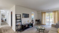 Located at 150-A Willowdale Dr in Frederick, Maryland, this single-floor residence offers three bedrooms and two bathrooms within a well-organized and efficiently designed layout. The entrance leads into a carpeted living room that flows seamlessly into the dining area, creating an open and connected social space. The living room features large sliding glass doors dressed with sheer gold curtains, allowing natural light to fill the room and providing access to the outdoors. The dining area is accented by a multi-bulb chandelier and decorative wall shelving, adding character to the space.

The galley-style kitchen is outfitted with warm-toned wood cabinetry, granite-look countertops, a stainless steel sink, and black appliances including a refrigerator and range. It opens directly into the dining area, making it convenient for everyday living and entertaining. The primary bedroom is generously sized with plush carpeting and ample room for full bedroom furnishings. The additional bedrooms are similarly finished with neutral tones and soft carpet. Both bathrooms feature clean, light finishes, with hardwood-style flooring and tub-shower combinations. Throughout the residence, neutral wall colors and consistent flooring choices create a cohesive and comfortable atmosphere.