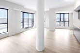 Located at 3385 Dundas St W in Toronto's vibrant west end, this three-bedroom, two-bathroom unit offers a well-designed layout across a single floor. Light-toned hardwood flooring runs throughout, complementing the clean, modern aesthetic.

The open-concept kitchen and living area serves as the heart of the unit. The kitchen features sleek slate-blue cabinetry extending to the ceiling, white subway tile backsplash, light quartz countertops, a stainless steel sink, and a full suite of stainless steel appliances including a dishwasher, range, built-in microwave, and refrigerator. A structural column adds architectural character to the space.

The living room is bright and airy, with large black-framed floor-to-ceiling windows and a sliding glass door that opens to a balcony, offering expansive city views. The primary bedroom continues this theme with generous glazing and direct balcony access, filling the room with natural light.

The two additional bedrooms are well-proportioned with light hardwood floors and neutral walls. Two bathrooms serve the unit: one features a glass-enclosed walk-in shower with white tile surround, while the other includes a grey vanity with a white countertop, a mirror with overhead lighting, and a combined tub and shower. A hallway connects all rooms, with a closet providing additional storage.