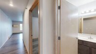 Located at 1418 First Ave N in Fargo, North Dakota, this well-designed one-bedroom, one-bathroom unit offers a functional and modern living experience across a single floor. The open-concept layout seamlessly connects the kitchen and living room, creating a bright and airy atmosphere enhanced by large windows and a sliding glass door that invite generous natural light into the space.

The kitchen is a standout feature, equipped with stainless steel appliances including a refrigerator, range, microwave, and dishwasher. Rich, two-toned cabinetry — warm wood uppers paired with slate-blue lower cabinets — sits against clean light countertops, all accented by recessed ceiling lighting that adds a polished touch.

The living area is spacious and open, with wide-plank wood-look flooring that flows consistently throughout the unit, tying all rooms together with a cohesive, contemporary feel. Baseboard heating is present throughout.

The bedroom offers a comfortable footprint with its own walk-in closet featuring built-in wire shelving, providing ample storage. The bathroom includes a clean, all-white stand-alone shower unit. A dedicated laundry room with a stacked washer and dryer adds exceptional in-unit convenience, rounding out this efficiently designed and move-in-ready home.