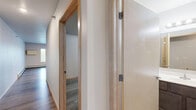 Located at 1418 First Ave N in Fargo, North Dakota, this well-designed one-bedroom, one-bathroom unit offers a functional and modern living experience across a single floor. The open-concept layout seamlessly connects the kitchen and living room, creating a bright and airy atmosphere enhanced by large windows and a sliding glass door that invite generous natural light into the space.

The kitchen is a standout feature, equipped with stainless steel appliances including a refrigerator, range, microwave, and dishwasher. Rich, two-toned cabinetry — warm wood uppers paired with slate-blue lower cabinets — sits against clean light countertops, all accented by recessed ceiling lighting that adds a polished touch.

The living area is spacious and open, with wide-plank wood-look flooring that flows consistently throughout the unit, tying all rooms together with a cohesive, contemporary feel. Baseboard heating is present throughout.

The bedroom offers a comfortable footprint with its own walk-in closet featuring built-in wire shelving, providing ample storage. The bathroom includes a clean, all-white stand-alone shower unit. A dedicated laundry room with a stacked washer and dryer adds exceptional in-unit convenience, rounding out this efficiently designed and move-in-ready home.
