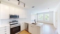 Located at 517 N Shipley St in Wilmington, Delaware, this thoughtfully designed one-bedroom, one-bathroom unit offers a clean, modern aesthetic across a single floor. Light-toned hardwood-style flooring runs throughout the living areas and bedroom, creating a warm and cohesive feel.

The kitchen is outfitted with sleek white cabinetry extending to the ceiling, providing ample storage, and is equipped with a full suite of stainless steel appliances including a refrigerator, electric range with microwave, and dishwasher. The crisp white countertops and minimalist hardware give the space a contemporary, polished look.

The living area is bright and open, benefiting from large windows that invite natural light and offer views of surrounding greenery. The entry features a modern keypad-equipped door, reinforcing the unit's up-to-date finishes.

The bedroom is a comfortable, well-proportioned retreat with large windows framing tree-lined outdoor views, allowing sunlight to fill the space. A closet provides convenient storage.

The bathroom is finished to a high standard, featuring large-format light tile flooring, a white vanity with matte black fixtures, a well-lit mirror, and a glass-enclosed walk-in shower with tasteful tile surround. The matte black hardware throughout adds a striking, modern accent. The overall ambiance of the unit is clean, bright, and move-in ready.