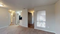 Located at Treeside Park, this single-floor residence offers a practical and comfortable layout designed for everyday living. The open living area is finished with plush carpeting and neutral-toned walls, creating a warm and inviting atmosphere. A sliding glass door leads to a private balcony, allowing natural light to fill the space while offering pleasant outdoor views. An adjacent window further brightens the room.

The kitchen features white cabinetry, dark granite-style countertops, a stainless steel sink, and black appliances including an electric range with overhead ventilation. The layout is efficient and well-organized, providing ample workspace and storage.

The two bedrooms are carpeted and generously sized, each with windows that bring in natural light and views of the surrounding greenery. One bedroom includes a spacious walk-in closet equipped with dual hanging rods and built-in shelving, offering exceptional storage capacity.

Two full bathrooms serve the residence, each featuring a tub-shower combination with tile surround. One bathroom includes wood-style flooring, while the other features a grey-toned finish. Both are clean and functional in design.

Throughout the home, consistent neutral tones and textured ceilings contribute to a cohesive, understated aesthetic well-suited for comfortable, practical living.