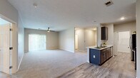 Located at 8800 Bradwell Pl in Fishers, Indiana, this single-floor, 3-bedroom, 2-bathroom home offers a well-designed layout with modern finishes throughout. The open-concept kitchen and living area serves as the heart of the home, featuring dark espresso cabinetry, a peninsula island with a white countertop, stainless steel appliances including a refrigerator, range, and microwave, and light wood-style flooring. A tiled backsplash adds a clean, contemporary touch to the kitchen. The living room flows seamlessly from the kitchen and is carpeted for comfort, with a ceiling fan overhead and a sliding glass door that opens to a balcony with outdoor views, allowing natural light to fill the space. The spacious primary bedroom features plush carpet, a ceiling fan, and its own en-suite bathroom complete with a floating vanity, white countertops, dark wood cabinetry, and wood-style tile flooring. The two additional bedrooms are well-proportioned with carpet flooring, ceiling fans, and windows offering natural light. A second full bathroom mirrors the same clean aesthetic with a tub-shower combo and matching vanity. The home also includes two closets with wire shelving and a dedicated utility room, providing ample storage throughout.