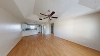 Located at 2501 Hibiscus Ave in McAllen, TX, this 2-bedroom, 1-bathroom unit offers a well-organized single-floor layout designed for comfortable everyday living. The open-concept living area immediately draws attention with its distinctive tray ceiling, textured finish, and a ceiling fan with integrated lighting. Warm laminate wood flooring extends throughout the main living spaces, adding a clean, cohesive look. Natural light flows in through windows fitted with blinds, brightening the interior throughout the day.

The kitchen connects seamlessly to the living area and features white cabinetry, a gray countertop with a breakfast bar peninsula, white appliances including a refrigerator and electric range, and a window above the sink. A dedicated laundry area with a washer and dryer is conveniently tucked adjacent to the kitchen.

The primary bedroom offers a comfortable footprint with laminate flooring, a ceiling fan, and a natural light-filled window. The second bedroom features plush carpeting, its own ceiling fan, a window, and a reach-in closet with bifold doors. The full bathroom is equipped with a tub-shower combo with tiled surround, a white vanity with storage cabinetry, and dark hardwood-style flooring, completing this functional and well-appointed home.