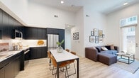 Located at 2555 Research Park Dr. in Davis, CA, this thoughtfully designed 3-bedroom, 3-bathroom single-story residence offers a contemporary living experience across a well-utilized floor plan. The open-concept kitchen and living area serves as the heart of the home, highlighted by dramatically soaring ceilings that amplify the sense of space. The kitchen features sleek, floor-to-ceiling matte black cabinetry, white tile backsplash, stainless steel appliances, and bright white countertops — a refined, modern aesthetic. Light wood-look flooring runs throughout, creating a warm and cohesive feel. The living area flows naturally from the kitchen and dining space, with tall windows and a glass door that draw in abundant natural light and provide direct access to a private patio. Each of the three bedrooms offers a comfortable, well-proportioned layout with ample closet storage. The primary bedroom includes its own en-suite bath, which features a dual-sink vanity with dark cabinetry and a full-width mirror. Additional bathrooms maintain the same modern design language with dark vanities and clean white finishes. An in-unit laundry area adds everyday convenience. This residence combines modern design with practical functionality in a prime Davis location.