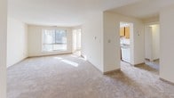 Located in Building 3900 of Greencastle Ridge Terrace in Burtonsville, Maryland, this single-floor unit offers a clean, bright, and functional layout throughout. The living area is generously sized, featuring plush wall-to-wall carpeting and large windows that invite abundant natural light, creating a warm and airy atmosphere. The space flows seamlessly toward a separate kitchen, which is equipped with warm honey-toned wood cabinetry lining both walls, a white electric range, a refrigerator, and a double sink set beneath ample counter space. Tile flooring runs throughout the kitchen, adding durability and easy maintenance. The bedrooms are well-proportioned, each carpeted and bathed in natural light. One bedroom features a bifold-door closet with a hanging rod, while the primary bedroom includes a walk-in closet with built-in shelving, offering excellent storage capacity. A bathroom with tile flooring, a rich dark wood vanity, a wide countertop with an integrated sink, a large mirror, and overhead lighting completes the unit. The neutral color palette and clean lines throughout the space provide a versatile canvas well-suited for a variety of interior styles. The overall ambiance is calm, practical, and move-in ready.