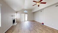 Located at 3501 S McClintock Dr in Tempe, Arizona, this single-story home offers four bedrooms and two bathrooms across a well-organized layout. The living room immediately impresses with soaring vaulted ceilings, a ceiling fan with light fixture, and a tile-surround fireplace. A sliding glass door and a decorative transom window above it flood the space with natural light, while wood-look flooring adds warmth and continuity throughout. The kitchen is thoughtfully designed with crisp white shaker cabinetry, white subway tile backsplash, light countertops, and stainless steel appliances including a range, microwave, dishwasher, and refrigerator. A window above the sink brings in additional natural light. The bedrooms feature plush carpeting and built-in closets with shelving, offering practical storage solutions. The hallways connect the rooms efficiently, with one hallway showcasing a walk-in style closet. The bathrooms are clean and functional, appointed with wood-look tile flooring, a single-sink vanity with a large mirror, and a shower-tub combination. Neutral tones and consistent finishes throughout the home create a cohesive and move-in-ready atmosphere well-suited to the sunny Tempe climate.