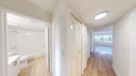 Located at Lakepointe Landing in Plantation, Florida, this efficiently designed one-bedroom, two-bathroom residence offers a well-organized single-floor layout with a clean, modern aesthetic throughout. Light wood-style flooring flows through the main living areas and bedroom, complementing the bright white walls and textured ceilings that give the space an airy, open feel. The living room is bathed in natural light and features a sliding glass door that opens to a view of lush greenery, creating a seamless indoor-outdoor connection. The open-concept kitchen is equipped with stainless steel appliances, white cabinetry, a mosaic tile backsplash, and a peninsula breakfast bar with track lighting above, making it both functional and visually appealing. The spacious bedroom offers ample room and connects to a well-appointed en-suite bathroom that includes a large vanity with white countertops, a mirrored sliding closet with built-in shelving, and a separate water closet. A second full bathroom features a tub-shower combo, single vanity, and neutral tile flooring. A hallway with louvered bi-fold closet doors adds convenient storage, while a dedicated entrance and additional closet space enhance practicality. Natural light is present throughout, contributing to the residence's bright and inviting ambiance.