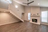 Located at 11800 Grant Rd in Cypress, Texas, this two-story home offers a clean, modern aesthetic throughout both levels. The main floor features durable wood-look luxury vinyl plank flooring that flows through the open living area and into the galley-style kitchen. The kitchen is well-appointed with gray shaker cabinets, white quartz countertops, a classic subway tile backsplash, stainless steel appliances, and a double-basin sink — combining style with functionality. A dedicated laundry area with washer and dryer hookups adds everyday convenience. The staircase, finished with a white balustrade railing, leads to the upper level, where a generously sized loft or bonus living space awaits, complete with wood-look flooring and a ceiling fan. The carpeted bedrooms are comfortably scaled and feature ceiling fans and recessed lighting. One bedroom includes access to a walk-in closet outfitted with wire shelving, while another connects to a bathroom vanity area featuring gray cabinetry, quartz countertops, and a large mirror with brushed nickel accents. Neutral gray tones, crisp white trim, and recessed lighting throughout lend the home a cohesive, contemporary feel.