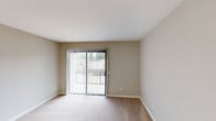 Located at 1361 W 9th in Escondido, this single-floor unit offers a well-organized layout with a clear separation between living, kitchen, and bedroom spaces. The open-concept living and dining area features light wood-style flooring and is anchored by a ceiling fan, with sliding glass doors fitted with vertical blinds providing access to a private balcony and bringing in ample natural light and outdoor views.

The kitchen is thoughtfully updated, featuring crisp white shaker-style cabinetry with ample storage, dark countertops, and a full suite of stainless steel appliances including a refrigerator, range with microwave above, and sink. A peninsula counter separates the kitchen from the living area, offering a practical transition between the two spaces. Light wood-style flooring runs throughout the kitchen, complementing the neutral wall tones.

The bedrooms are carpeted and finished in warm neutral tones, each offering a calm and comfortable atmosphere. One bedroom features a sliding glass door to the balcony, while another includes a window with outdoor views. White baseboards throughout provide clean, consistent finishing detail. Overall, the unit presents a practical and well-maintained living space with updated finishes.