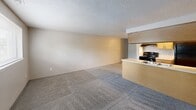 Located at 2714 S Emporia St in Wichita, KS, this one-bedroom, one-bathroom apartment offers a functional and efficiently designed single-floor layout. The open-concept living and kitchen area forms the heart of the unit, featuring a peninsula-style kitchen with light wood cabinetry, a double sink, black appliances including a range and refrigerator, and wood-look flooring that transitions into carpet in the living space. A textured popcorn ceiling is consistent throughout the unit, lending a classic residential feel. The spacious living area provides ample room for furnishings and is complemented by neutral-toned walls. The bedroom is a comfortable size, featuring plush carpeting, a window with blinds that allows natural light, and dual closets offering generous storage. An additional carpeted room with a ceiling fixture provides flexible use as a secondary living or flex space. The bathroom is fitted with a full tub-shower combination accented by white tile surround and wood-toned cabinetry. An in-unit laundry area adds everyday convenience. Overall, the apartment presents a straightforward, practical living environment well-suited for individuals or couples seeking an efficient and functional home in Wichita.