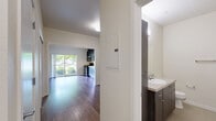 Located at 470 Alexander Loop in Eugene, Oregon, this compact and efficiently designed unit offers a well-organized single-floor layout that makes smart use of every square foot. The open living area features warm hardwood-style flooring and clean, light-colored walls that create a bright and welcoming atmosphere, with a wall-mounted heating unit providing year-round comfort.

The kitchen is a standout feature, designed with a sleek, modern aesthetic. Dark-toned flat-front cabinetry extends floor to ceiling, providing ample storage. A full suite of stainless steel appliances includes a range with oven, built-in microwave, dishwasher, and a full-size refrigerator, all complemented by a double-basin sink and light-toned countertops.

The bathroom is practical and well-appointed, featuring a vanity with a wide countertop, undermount sink, wood-toned cabinetry, and a large mirror. A notable convenience is the inclusion of a stacked full-size washer and dryer unit housed directly within the bathroom, eliminating the need for shared laundry facilities.

A hallway connects the main living space to the bathroom and entry door, contributing to the efficient flow of the layout. The unit's clean, contemporary finishes and functional design make it a practical and comfortable space in Eugene's 97401 corridor.