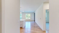 Located at 2152 Middleton Beach Rd in Middleton, WI, this one-bedroom, one-bathroom unit offers a well-designed single-level layout with a clean, contemporary aesthetic throughout. Light-toned luxury vinyl plank flooring runs through the main living areas, complementing the bright, neutral color palette that gives the space an open and airy feel.

The kitchen is a standout feature, centered around a white island with a built-in sink and pendant lighting overhead. White cabinetry with modern hardware lines the walls, paired with a subway tile backsplash and stainless steel appliances including a range, built-in microwave, and French door refrigerator. The kitchen flows seamlessly into the living area, which benefits from natural light and direct access to an outdoor balcony overlooking a scenic green landscape.

The bedroom is carpeted for comfort and includes a ceiling fan, a large window, and balcony access with pleasant outdoor views. The full bathroom features a tub/shower combination, white vanity with a clean countertop, light wood-style flooring, and brushed nickel hardware and towel bars. A dedicated laundry area houses a stacked washer and dryer unit, adding practical convenience. Overall, the space presents a modern, functional design suited for comfortable everyday living.