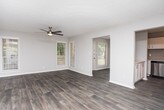 This single-floor residence offers a thoughtfully designed layout with a clean, modern aesthetic throughout. The open living area features dark luxury vinyl plank flooring and a ceiling fan, creating a comfortable and stylish environment. Natural light flows in through a window, adding warmth to the space. An adjacent dining area is accented by a contemporary chandelier, making it well-suited for everyday meals or entertaining.

The kitchen is a standout feature, showcasing crisp white shaker cabinetry, light quartz countertops, a gray subway tile backsplash, and stainless steel appliances including a gas range with overhead microwave and dishwasher. Wood-look flooring and a window above the sink round out this functional and attractive space.

The bedrooms are carpeted for comfort, with multiple rooms offering natural light through blinds-covered windows. The primary bedroom connects to a well-appointed bathroom featuring a white vanity with quartz countertop and an adjoining walk-in closet with wire shelving. Additional carpeted bedrooms provide flexible living options.

A dedicated laundry room with washer and dryer hookups, wire overhead shelving, and durable vinyl plank flooring adds everyday convenience. Neutral gray tones and updated finishes throughout give the home a cohesive, move-in ready appeal.