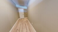 Located at 10 Fieldstone Cmn in Tolland, CT, this three-floor home offers a well-designed layout with two bedrooms and three bathrooms spread across a generous amount of living space. The main floor features an open-concept kitchen and living area, where white shaker cabinetry, stainless steel appliances, a peninsula with a sink, and light hardwood-style flooring create a clean, modern aesthetic with crown molding accents throughout. The living room is highlighted by a fireplace with a classic white mantle, a ceiling fan, and sliding glass doors that invite natural light. The upper floor hosts the spacious primary bedroom, complete with plush carpeting, crown molding, a ceiling fan, and a walk-in closet fitted with wire shelving systems. The bathrooms are finished with light hardwood-style flooring and natural light from windows. The lower level offers a large, open flex space with double doors to the outside, providing versatile use potential. An attached garage with an automatic opener adds everyday convenience. Hallways and staircases connect all three floors seamlessly, with light wood flooring and neutral warm-toned walls giving the home a cohesive, move-in-ready feel throughout.