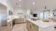 Located on West Colfax Avenue in Denver, Colorado, this well-appointed one-bedroom, one-bathroom residence offers a thoughtfully designed open-concept floor plan with modern finishes throughout. Light wood-tone flooring flows seamlessly across the entire space, complementing the bright, neutral color palette that creates an airy and welcoming ambiance.

The kitchen is a standout feature, showcasing a two-tone design with crisp white upper cabinetry and warm wood-finish lower cabinets, white quartz countertops, a classic tile backsplash, and a full suite of stainless steel appliances. A center island with bar seating provides additional prep and dining space, and recessed lighting overhead ensures the area is well-lit throughout the day.

The kitchen opens directly into the living room, which benefits from natural light streaming through a glass balcony door fitted with sheer curtains. A ceiling fan adds comfort, and the private balcony extends the living space outdoors.

The bedroom is generously proportioned, featuring a large window with balcony access, a ceiling fan, and a walk-in closet. The bathroom offers a sleek, elongated vanity with wood cabinetry, white countertop, black hardware accents, and large-format tile flooring. Additional conveniences include in-unit laundry and multiple closets for ample storage.