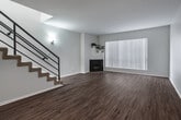 Located at 1936 Manning Ave in the desirable West Los Angeles neighborhood of 90025, this multi-floor property spans three levels connected by a modern staircase with sleek metal railings. The living areas feature warm wood-style flooring and recessed lighting, creating a bright, open atmosphere. Vertical blinds on sliding doors allow for adjustable natural light throughout.

The kitchen is well-appointed with white shaker cabinetry, marble-look quartz countertops, stainless steel appliances including a gas range, over-the-range microwave, and dishwasher, plus a skylight that floods the space with natural light. Bedrooms are carpeted for comfort and include mirrored sliding closet doors that enhance the sense of space.

The bathrooms are finished to a high standard, featuring white vanities with dual sinks, quartz countertops, wood-style flooring, and tiled shower-tub combinations with glass enclosures. One bathroom includes an illuminated mirror and a decorative patterned area rug, adding a stylish touch. The clean, neutral color palette throughout the property creates a cohesive and modern aesthetic, making this a well-maintained and thoughtfully updated multi-level residence in a prime Los Angeles location.