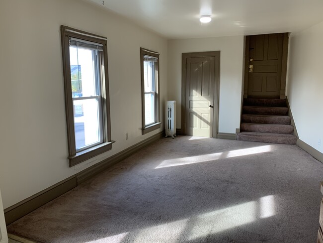 Living room w/ stairs to front entrance - 6 S Ellsworth St