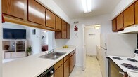 This single-floor residence offers a practical and comfortable layout designed for everyday living. The galley-style kitchen is efficiently arranged with warm wood cabinetry lining both walls, ample counter space, a double sink, an electric range, dishwasher, and a full-size refrigerator. A doorway at the end of the kitchen leads directly into a dedicated laundry room, where a full-size washer and dryer are conveniently housed.

The dining area sits adjacent to the kitchen and features carpeted flooring, a ceiling fan, and a bright, open feel. The living room is generously proportioned with plush carpeting, a large sliding glass door dressed in vertical blinds that allows natural light to fill the space, and a wall-mounted television setup.

The bedrooms are carpeted and well-sized, each featuring windows with vertical blinds that provide natural light and privacy. Ceiling fans are present in select rooms, enhancing comfort throughout.

A central hallway connects the main living areas to the bedrooms and bathroom, and includes a large sliding-door closet for additional storage. The full bathroom features classic mosaic tile flooring, a shower-tub combination, and clean, neutral finishes. The overall ambiance of the space is understated and functional, with a neutral color palette throughout.