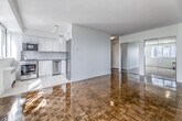 Located in the heart of Toronto's Church-Wellesley Village, this one-bedroom, one-bathroom unit at 100 Gloucester Street offers a well-designed and efficiently laid-out living space. The main living area is generously proportioned, showcasing gleaming parquet hardwood floors in a classic herringbone-style pattern that adds warmth and character throughout. Large windows flood the space with natural light and frame views of the surrounding Toronto skyline, while a baseboard radiator provides comfortable, even heating.

The bedroom is accessed through elegant mirrored sliding doors, which reflect light and enhance the sense of space. It mirrors the same polished parquet flooring and benefits from its own window with city views.

The kitchen is bright and modern, featuring white shaker-style cabinetry extending to the ceiling, a herringbone tile backsplash, light stone tile flooring, and a full suite of stainless steel appliances including a refrigerator, stove, built-in microwave, and dishwasher. Track lighting and a window ensure the kitchen is well-lit throughout the day.

The bathroom is finished in a clean, classic style with white subway tile walls, a stone tile floor, a soaking tub with shower, a vanity with mirror, and a medicine cabinet — offering a bright, functional retreat.