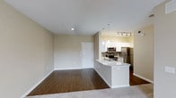Located at 1935 Northstar in San Marcos, Unit #3-376 is a thoughtfully designed single-floor residence that blends modern finishes with a functional, open-concept layout. The living area features warm hardwood-style flooring that flows toward plush carpeting, creating a comfortable and inviting atmosphere with a clear sense of distinct zones within the open plan. Neutral-toned walls and recessed lighting contribute to a clean, bright ambiance throughout. The kitchen is a standout feature, showcasing white cabinetry, light granite or stone countertops, and stainless steel appliances including a refrigerator, microwave, and range. A peninsula counter with pendant lighting overhead serves as both a prep space and a casual dining or gathering spot, elegantly separating the kitchen from the living area. Track lighting above the kitchen provides additional illumination, enhancing the workspace. The entry door is conveniently positioned within the main living space, offering a straightforward and welcoming entry point into the unit. Overall, the residence presents a contemporary and well-appointed interior that balances style and practicality in a cohesive, single-level design.